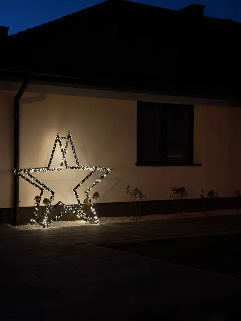 ModoStar-Stern an der Hauswand bei Nacht